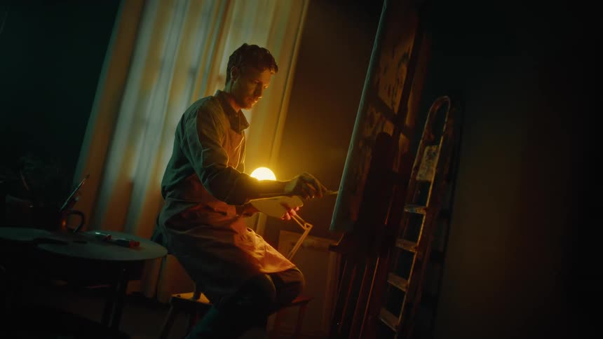 A man painting on a canvas in a room