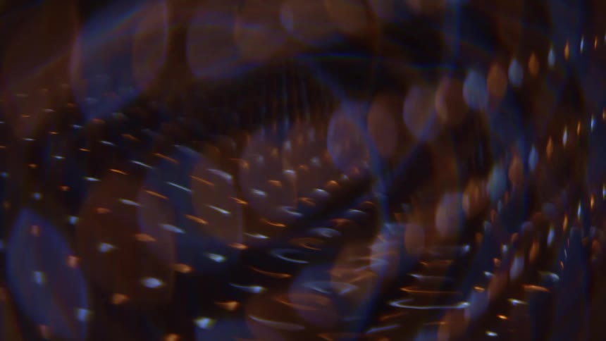 Outoffocus light dots and streaks in warm and cool tones forming curved and diagonal layers
