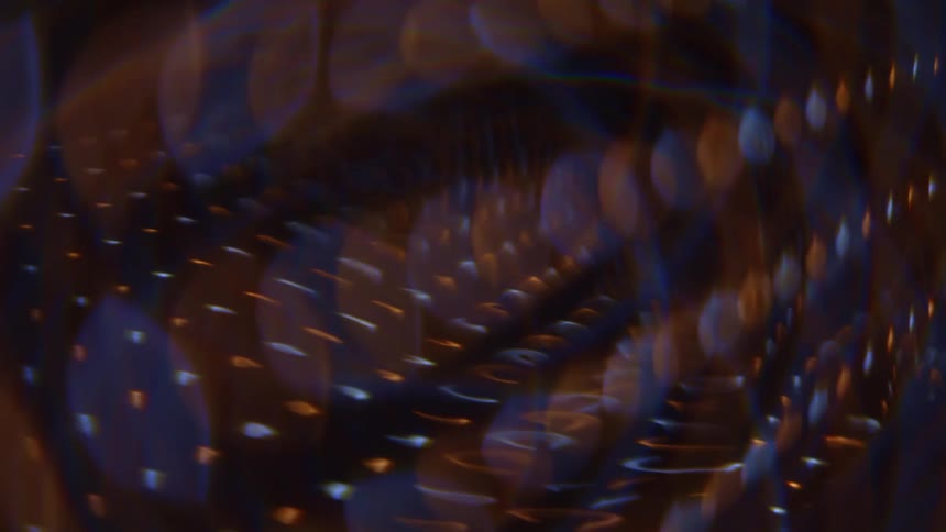 Outoffocus light dots and streaks in warm and cool tones distributed across diagonal layers