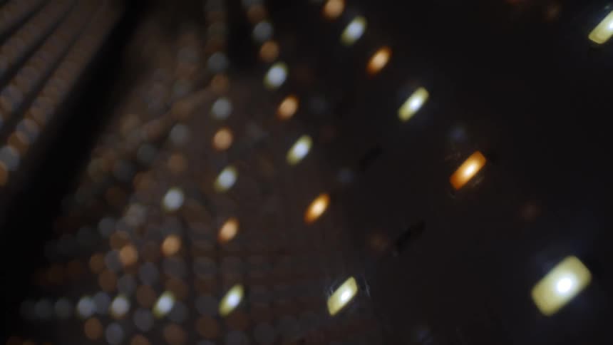 Outoffocus light points in warm and cool tones arranged in a diagonal pattern against a dark background