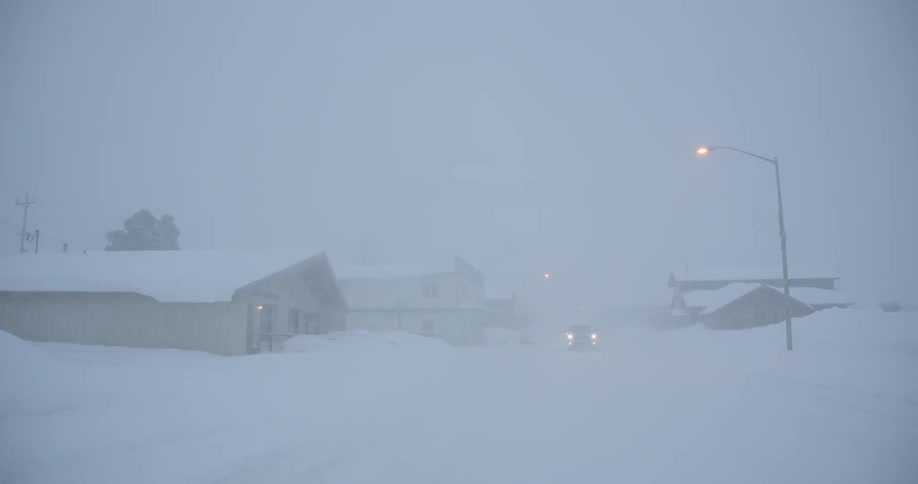 The truck drives through the blizzard in town