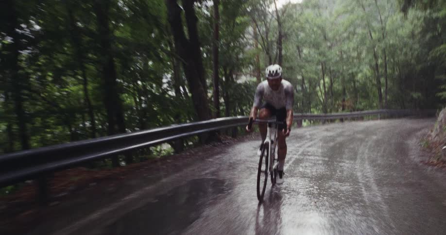 The man rides his bike in the rain