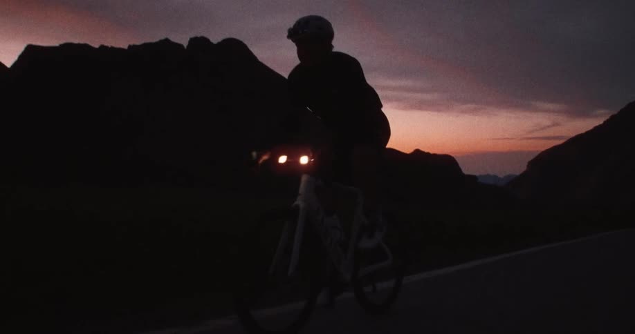 A man riding a bicycle outdoors at dusk