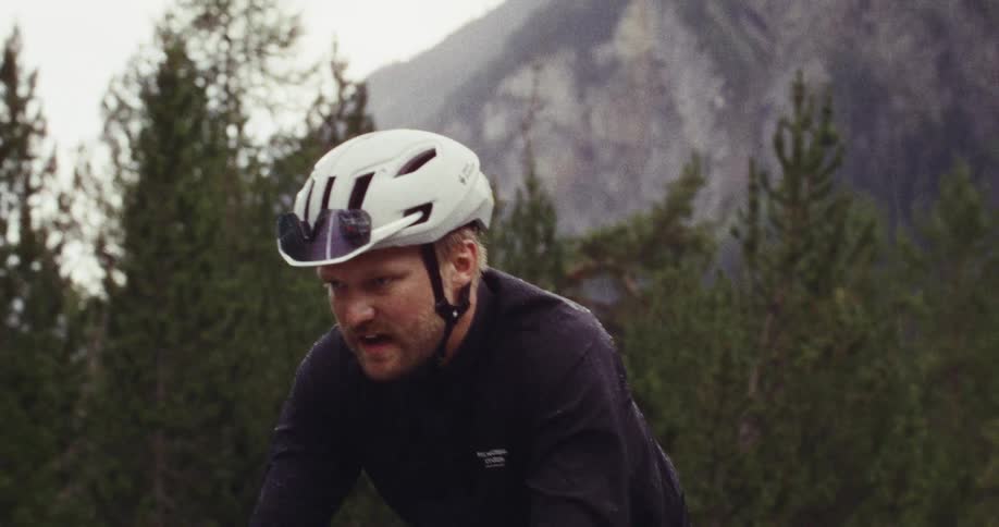 Man dripping in sweat as he rides his bicycle on a mountain road