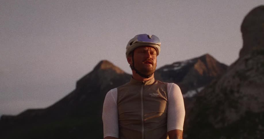 Cyclist stops to rest on a mountain road as he looks around