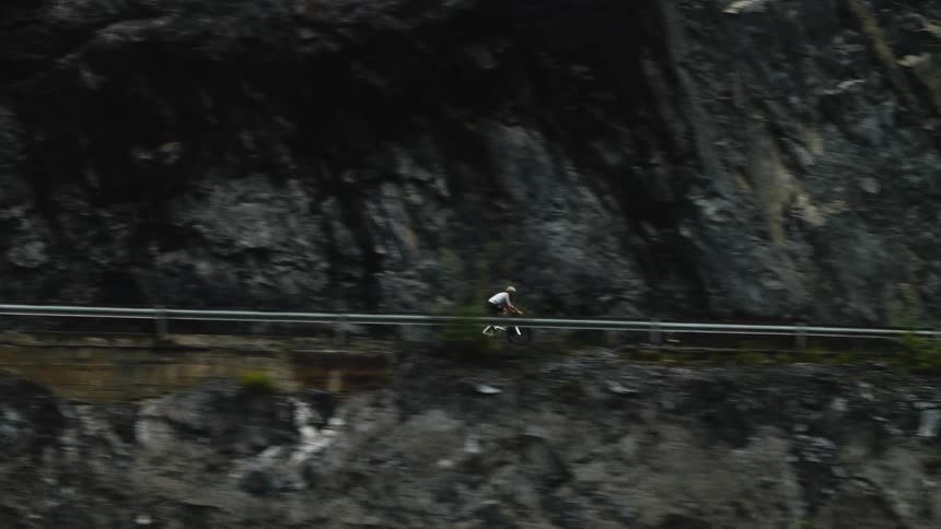 The cyclist travels on a trail on the cliff