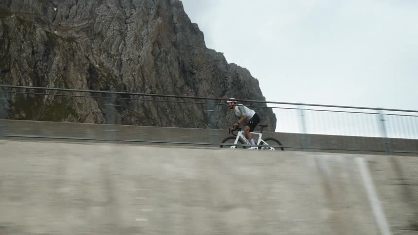 A man bikes atop a large stone wall