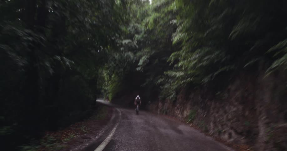A man riding a bicycle down a hill