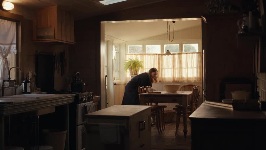 Woman catches a cat indoors walking through the kitchen