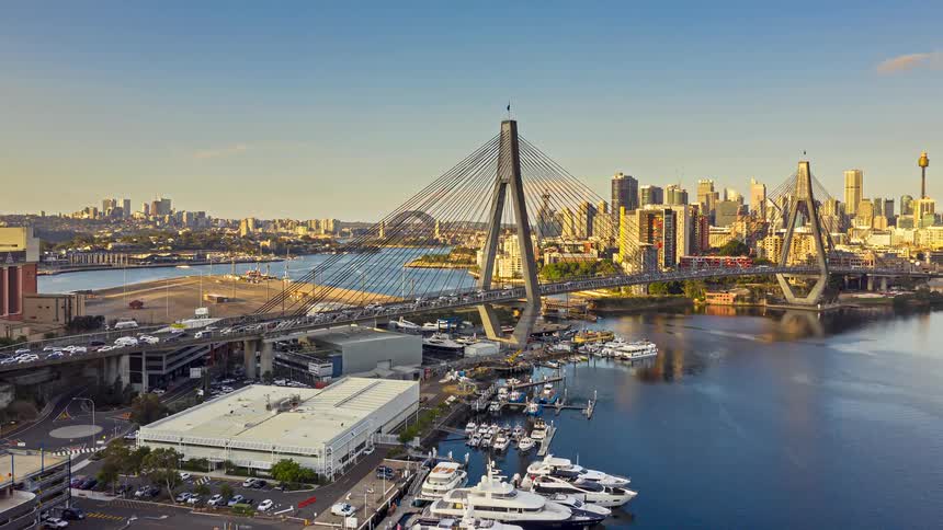Traffic crosses a busy cable bridge near a marina located near the city