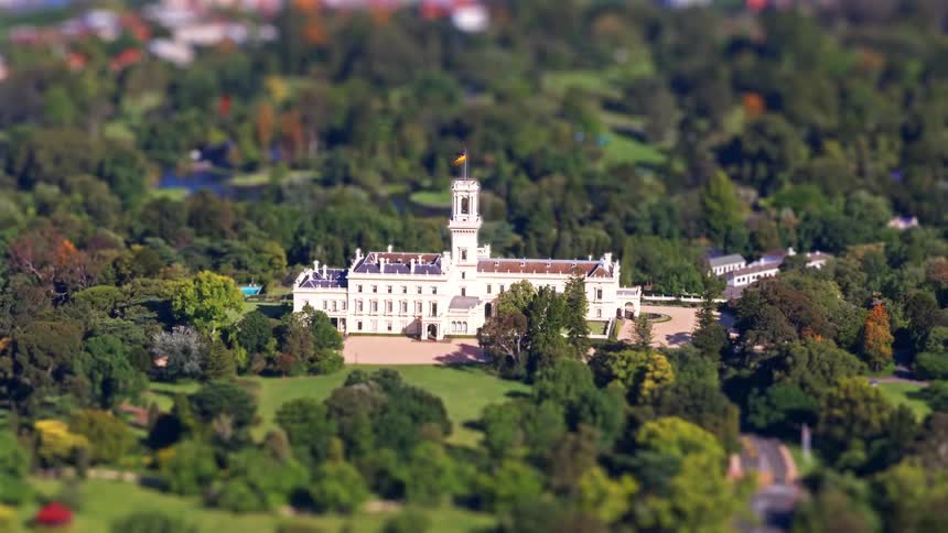 Historic classicalstyle building surrounded by green parkland in an aerial view