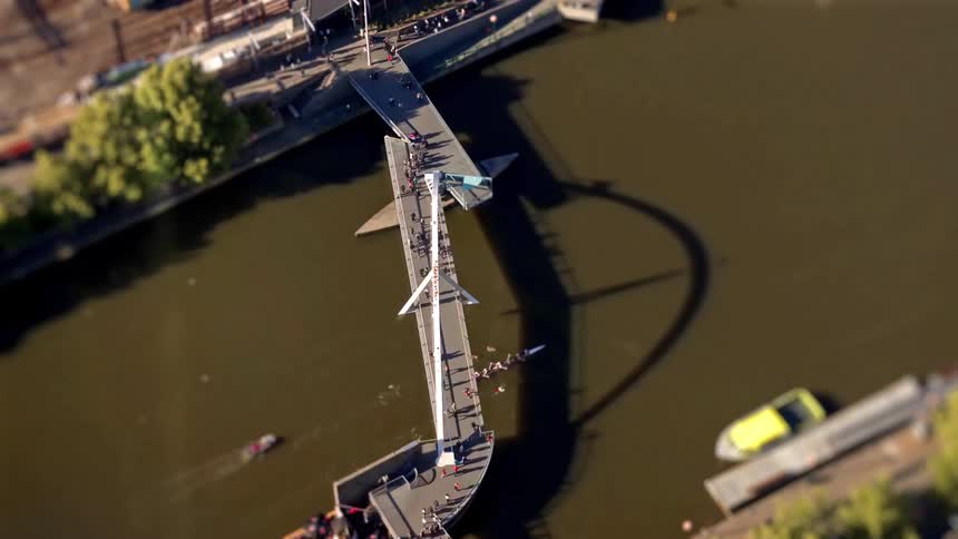 A group of people walking across a bridge in a city