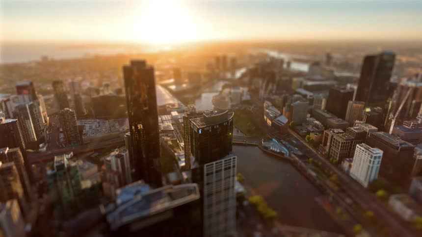 The city skyline transitions from a golden sunset to a sparkling nightscape