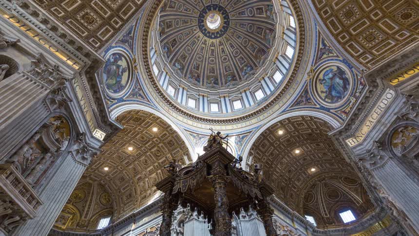 Ornate golden ceilings and a grand dome adorn the interior of a majestic cathedral