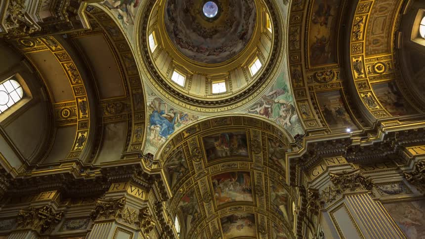 Interior of a historic building with an ornate dome frescoes and gilded architectural elements