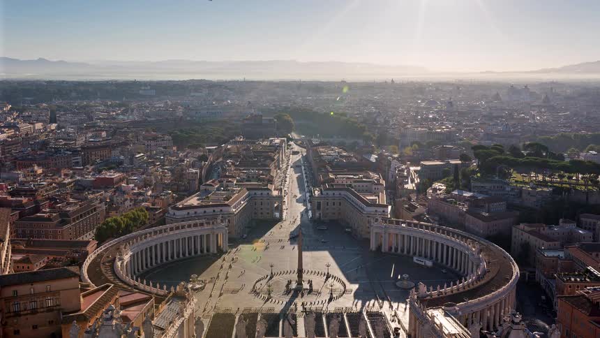 St peters square on a busy sunny day with people walking to and fro around the building