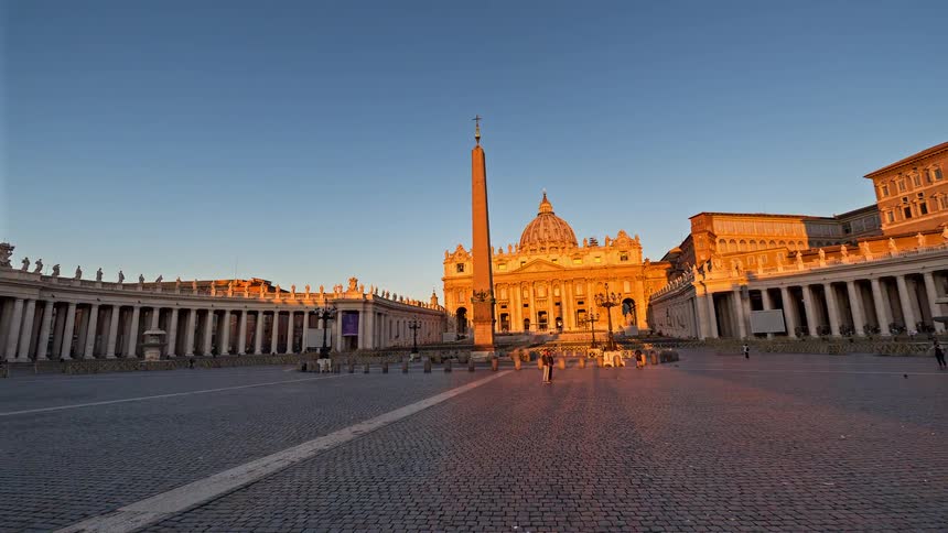 People passing through a square with an obelisk in the center surrounded by historic buildings in an urban area outdoors