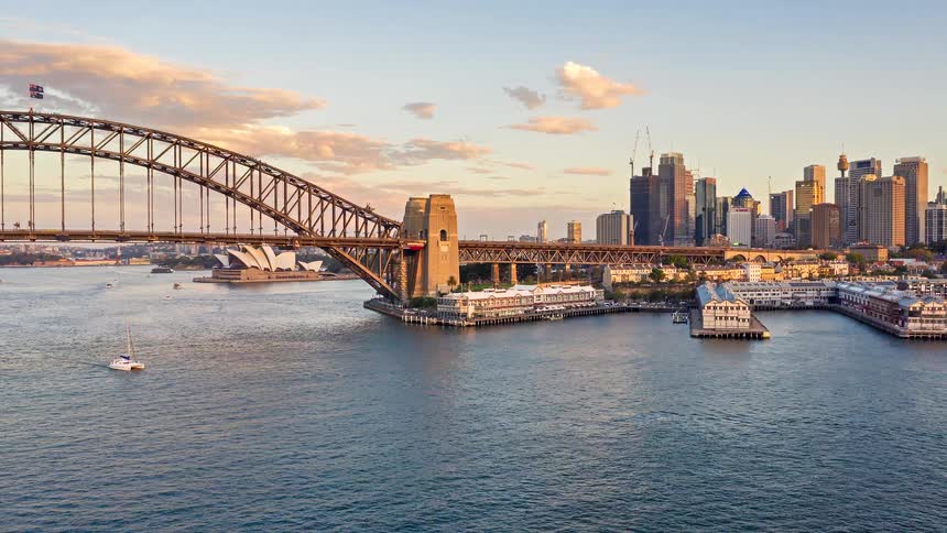 A large bridge over water leading into a city