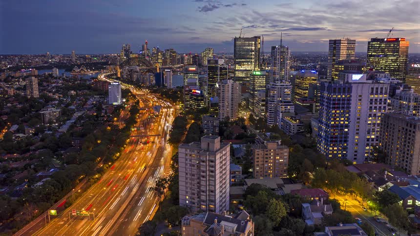 Aerial view of an urban area with highrise buildings and an expressway carrying heavy traffic at dusk