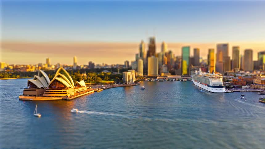 Sydney opera house on the left vessels in the harbor and the city skyline in the background under daylight