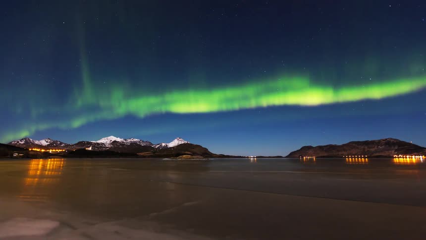 The green aurora flares in the night sky
