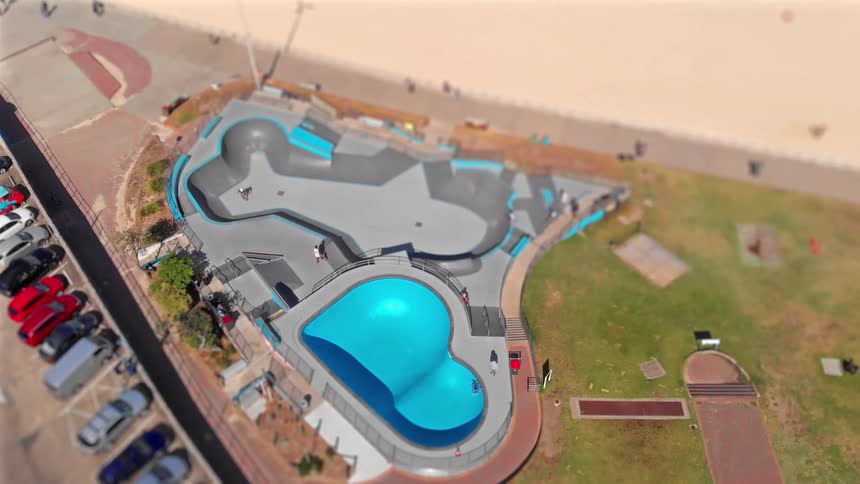 People are skating in the skate park by the beach