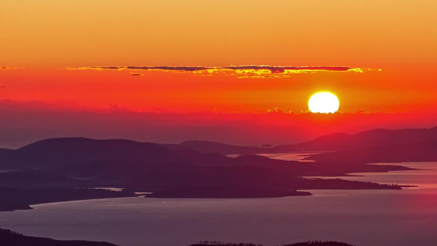 The sun slowly rises above the landscape