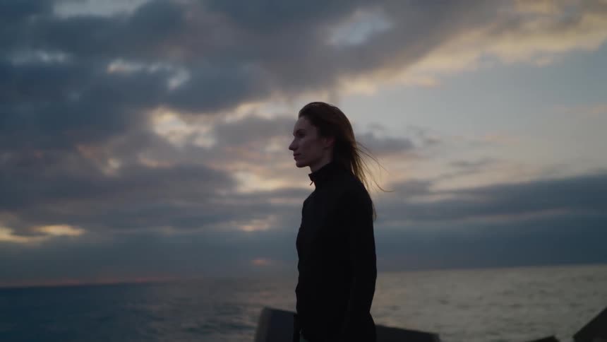 The woman looks out over the ocean