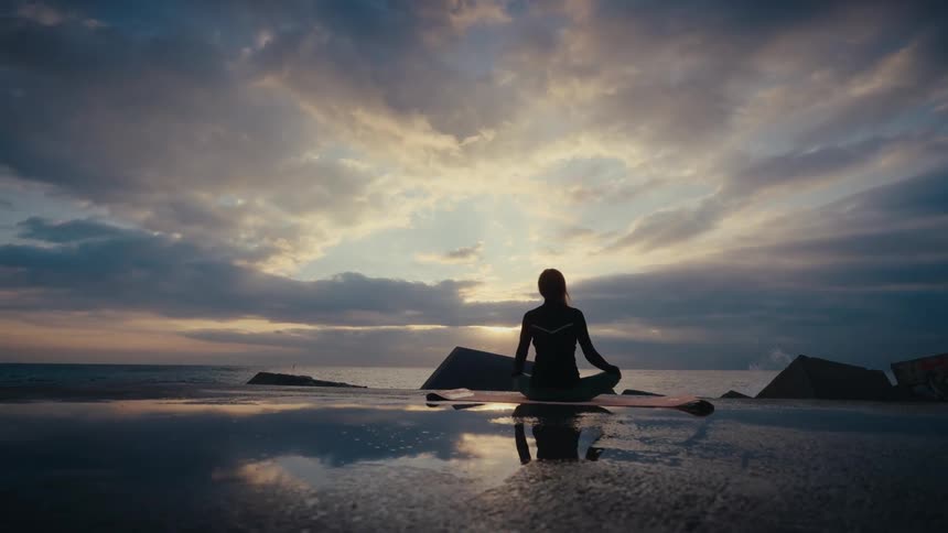A woman sitting outdoors meditating