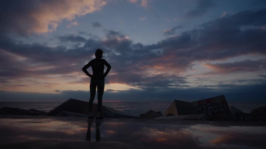 The woman stands in the shade at sunrise