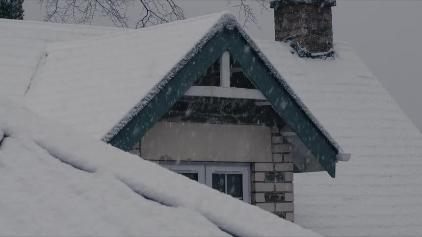A house getting snow on the roof