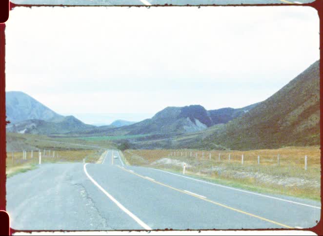 A car driving down a road on a sunny day