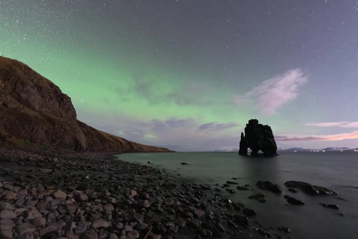 A view of a landscape with aurora in the distance