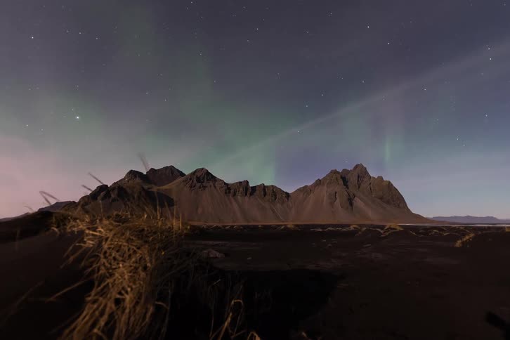 A view of a landscape with aurora above it