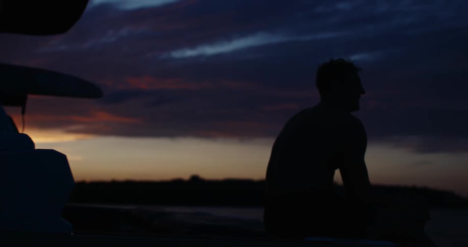 A man sitting on a boat at dusk