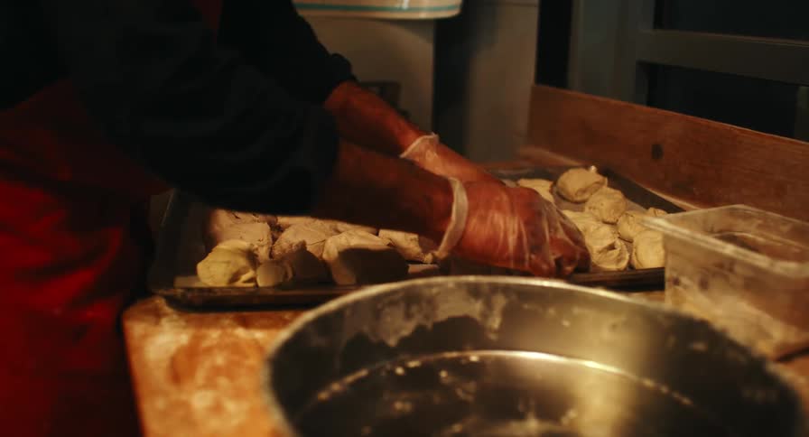 A person separating out dough on a tray