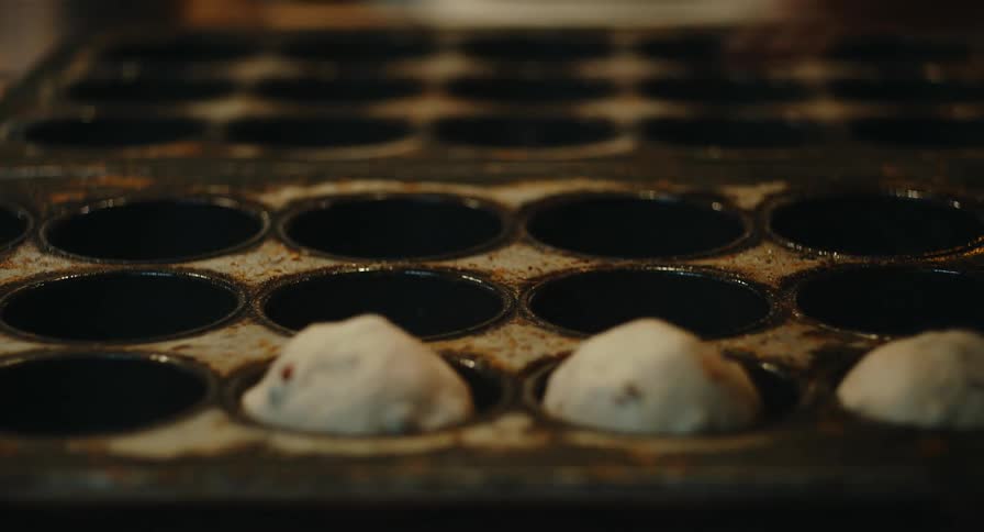 A person loading dough into trays