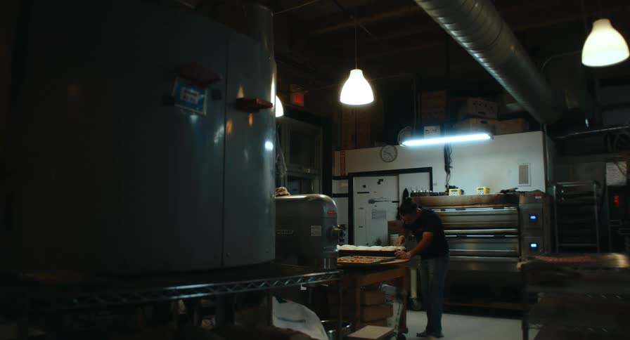 A man in a commercial kitchen prepares a tray of food
