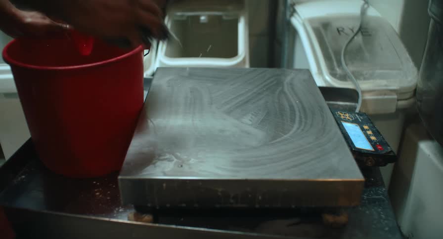 The man is cleaning the scale in the kitchen with soap and water