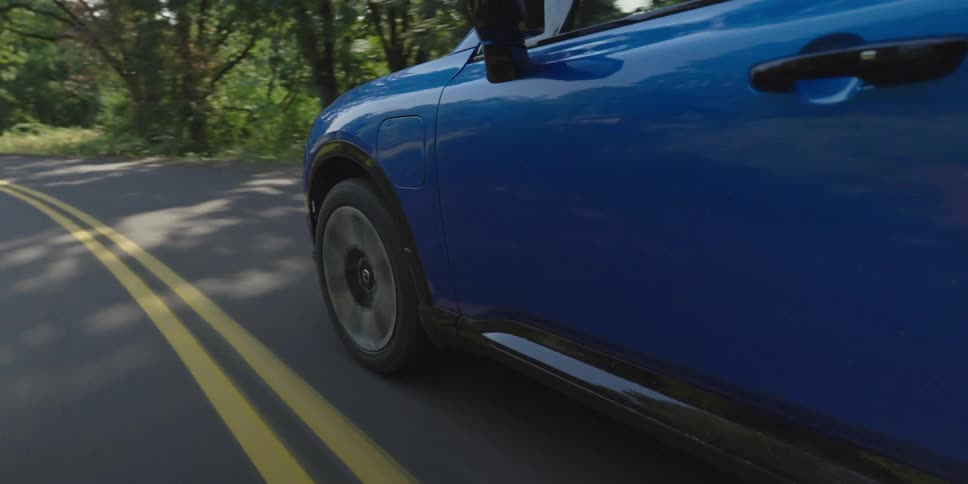 Car traveling on a road through a forested mountain