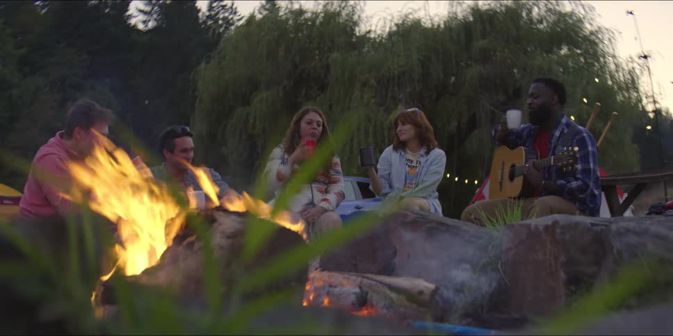 A group of people sitting around a campfire