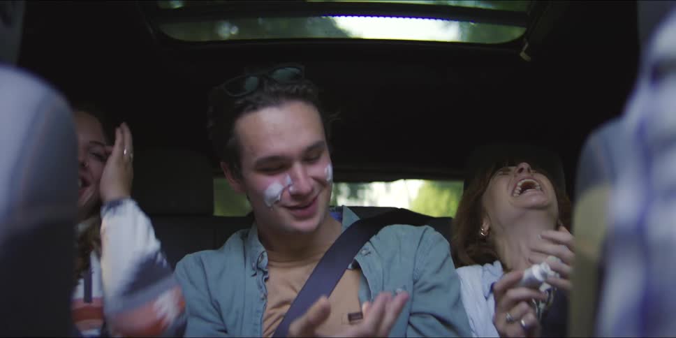 Three people sitting in the backseat of a car
