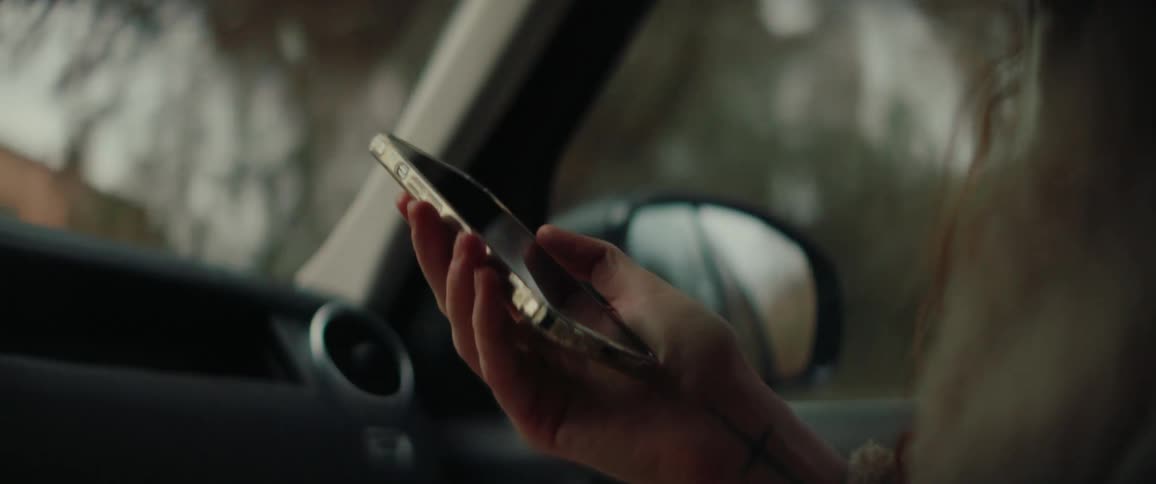 A woman using a smartphone in a car