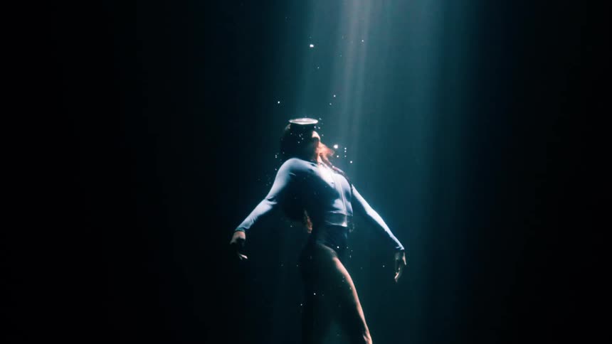 The woman is swimming underwater