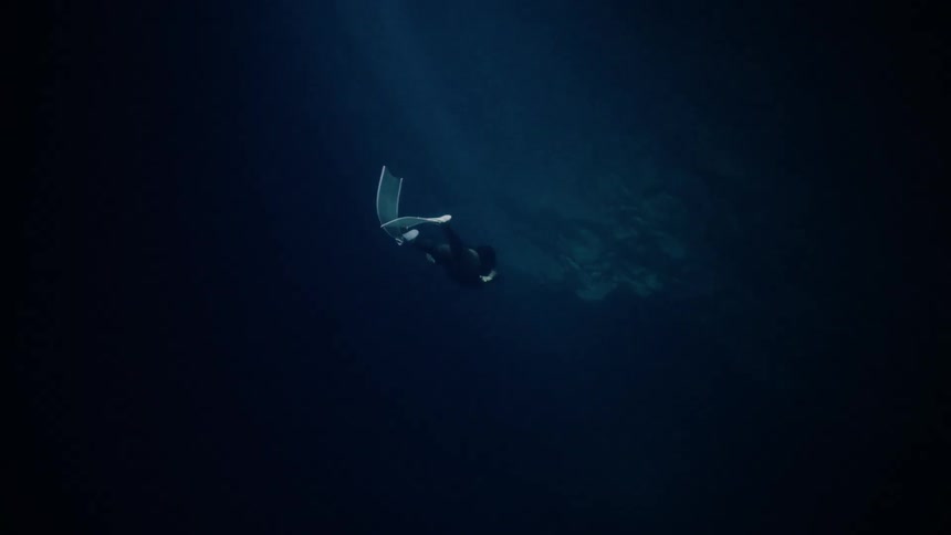 Woman wearing flippers swims underwater