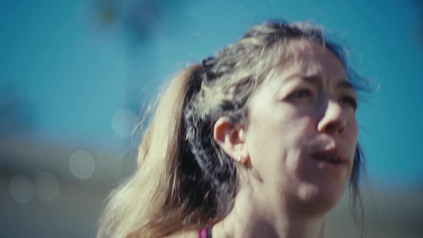 A woman exercising and doing squats outdoors