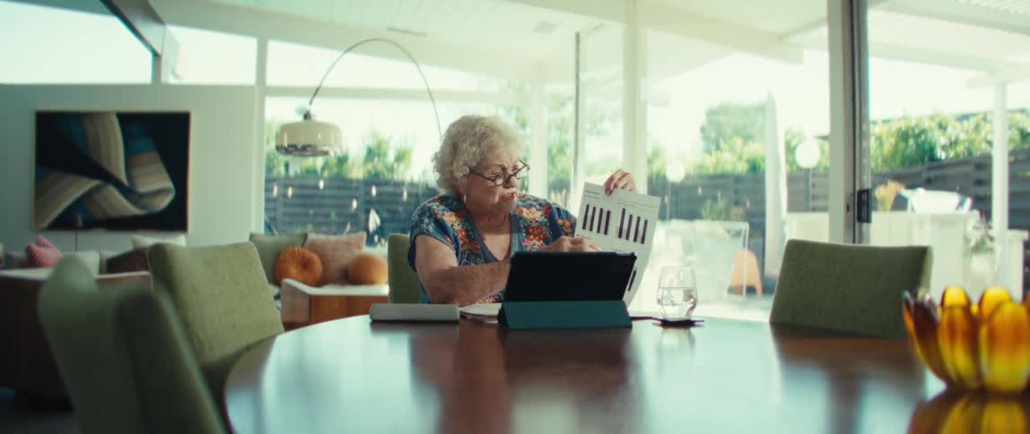 The woman points at paperwork in front of her tablet