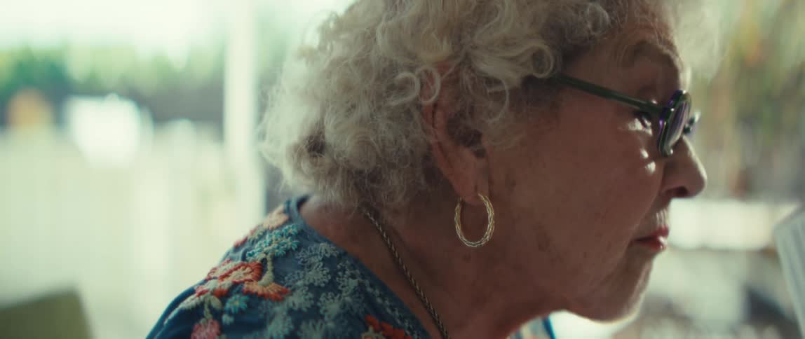The woman takes off her glasses while looking at the papers