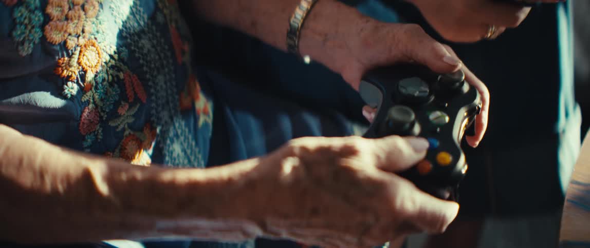 Two women sitting on a couch in the living room playing a video game with controllers