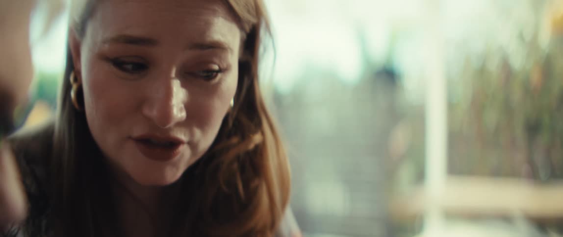 A woman reviews a printed report featuring several colorful doughnut charts while pointing at the data with a penshe then looks toward her companion and begins to speak her expression shifting from focused to engaged as they discuss the document